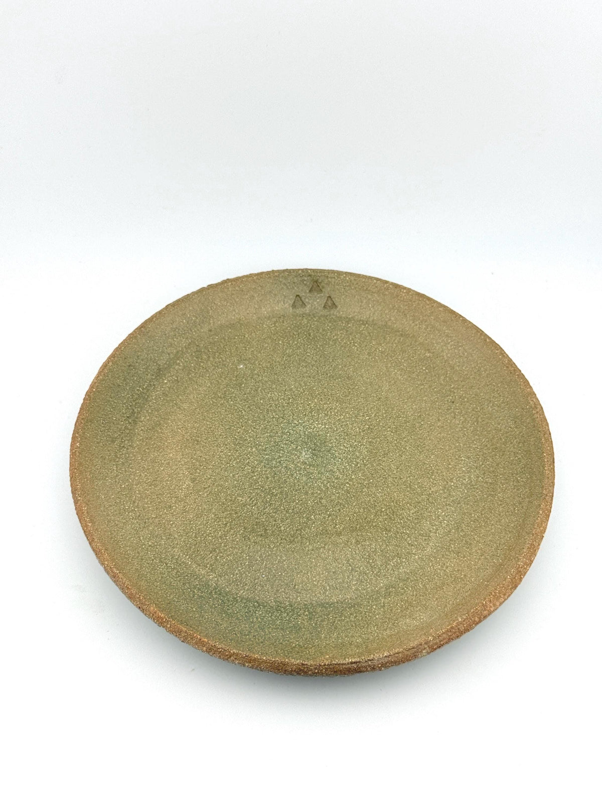 Assiette en grès roux chamotté, émail céladon laissant apparaître la texture minérale de la terre, Terres.me.