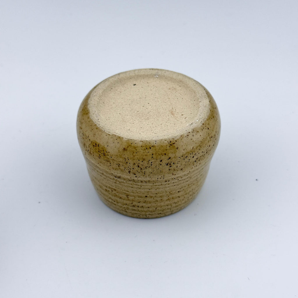 Détail du pied d'une tasse espresso artisanale en grès et sable de Sardaigne, émail miel brillant – Terres.me