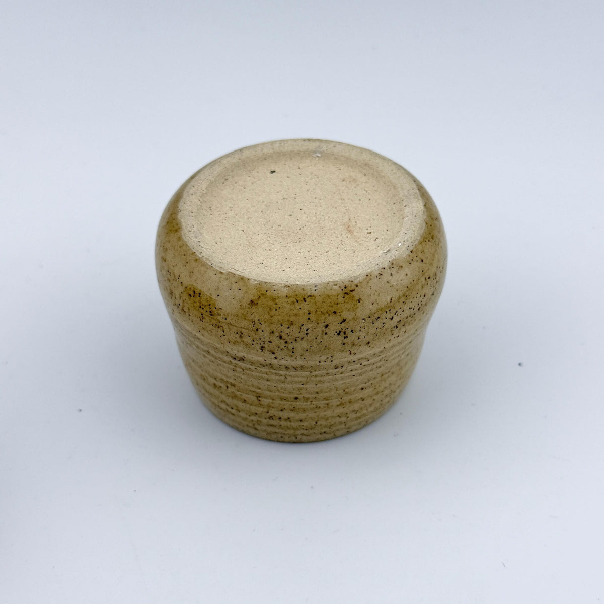 Détail du pied d'une tasse espresso artisanale en grès et sable de Sardaigne, émail miel brillant – Terres.me