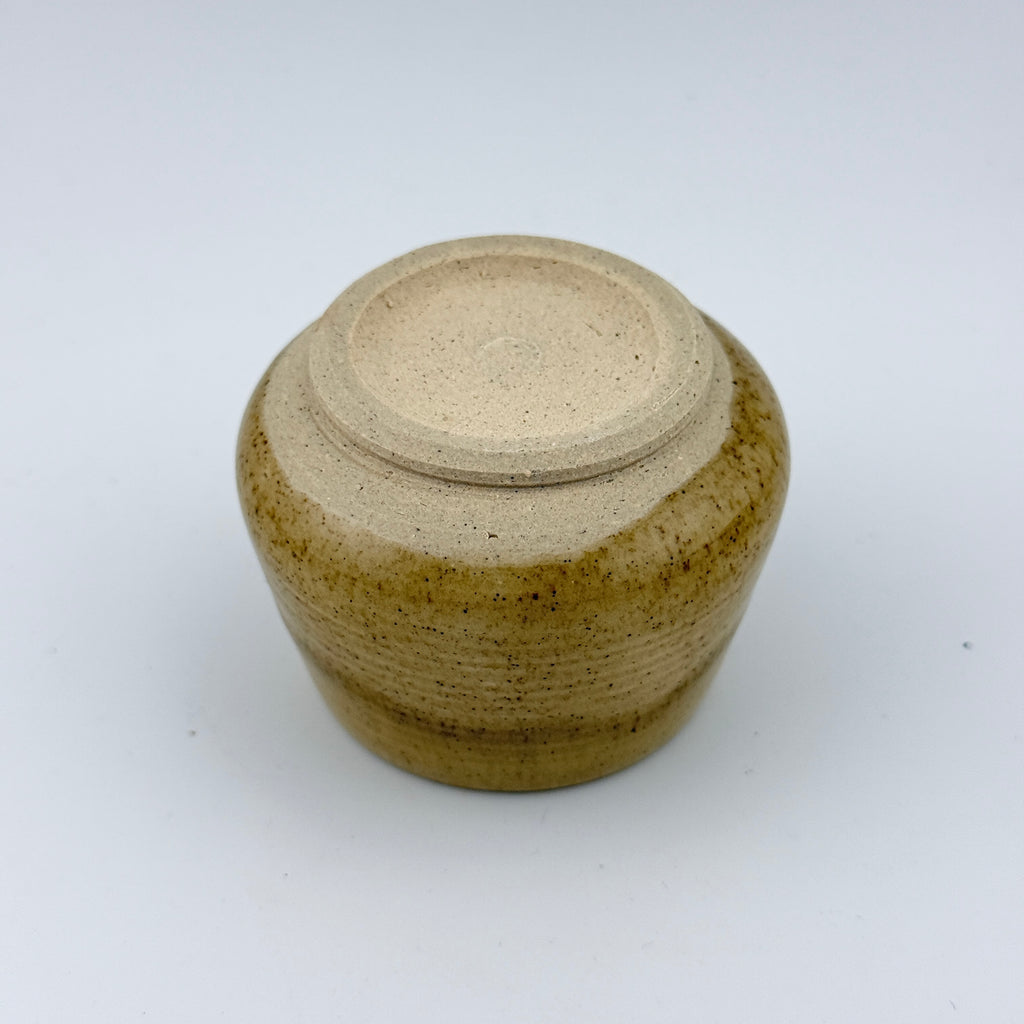 Détail du pied d'une tasse espresso artisanale en grès et sable de Sardaigne, émail miel brillant – Terres.me