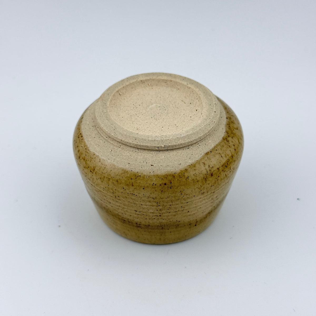 Détail du pied d'une tasse espresso artisanale en grès et sable de Sardaigne, émail miel brillant – Terres.me