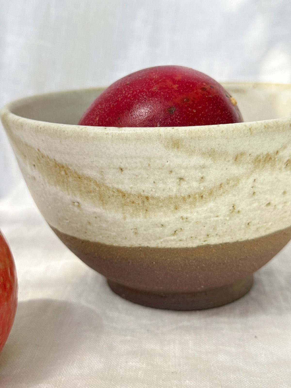 Grand bol artisanal aux tons rouge terre et blanc émaillé, pièce de céramique Terres.me.