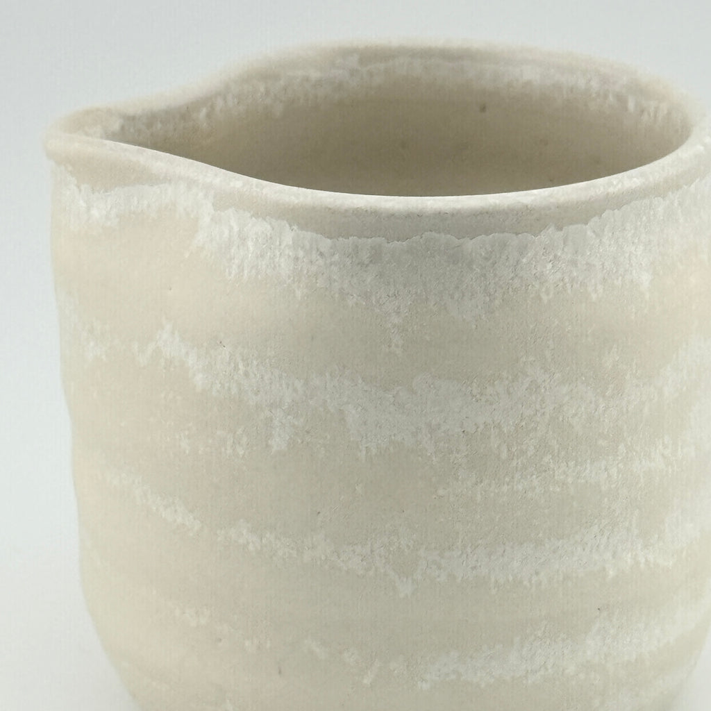 Détail de l’émail microcristallisé et du bec d’une tasse verseuse en porcelaine blanche