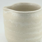 Détail de l’émail microcristallisé et du bec d’une tasse verseuse en porcelaine blanche