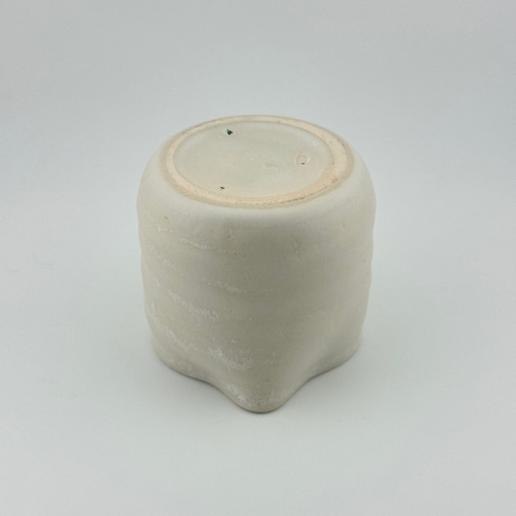 Dessous et pied de la tasse verseuse en porcelaine blanche microcristallisée