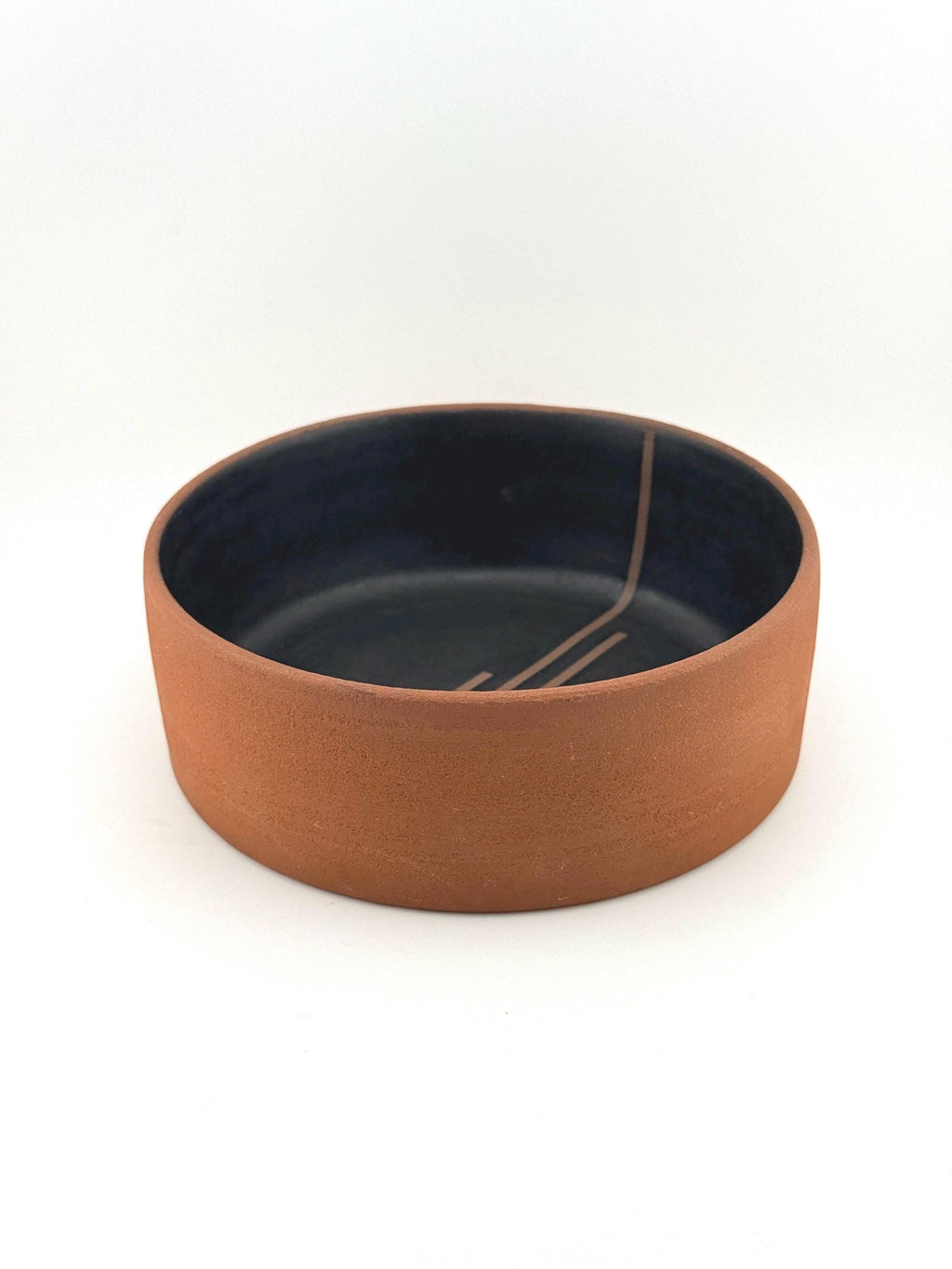 Saladier en grès rouge terracotta sans pied, fond plat et intérieur noir mat, artisanat Terres.me.