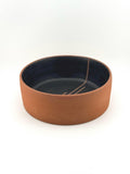 Saladier en grès rouge terracotta sans pied, fond plat et intérieur noir mat, artisanat Terres.me.
