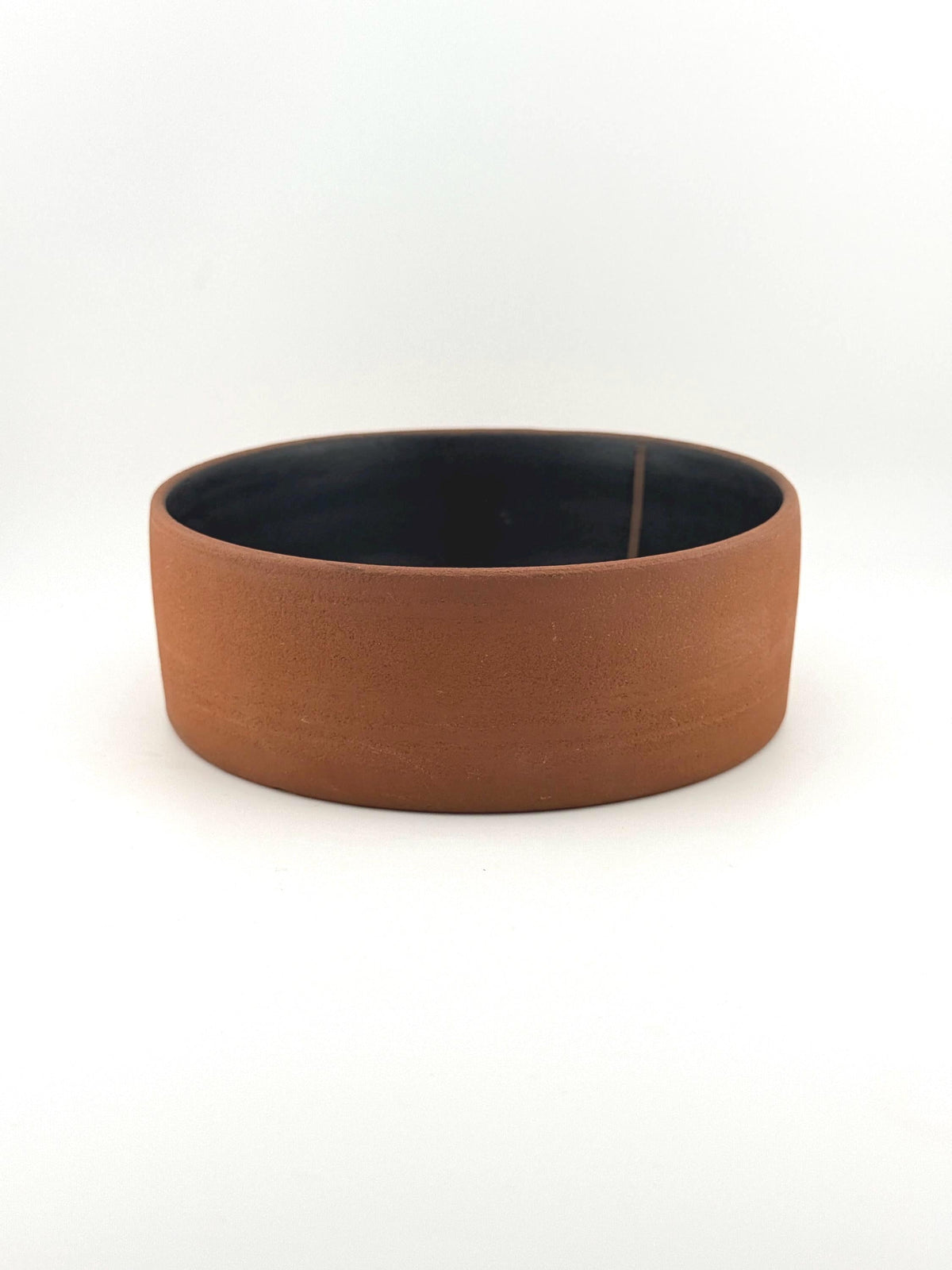 Saladier artisanal en grès terracotta, intérieur noir mat et extérieur brut, création Terres.me.