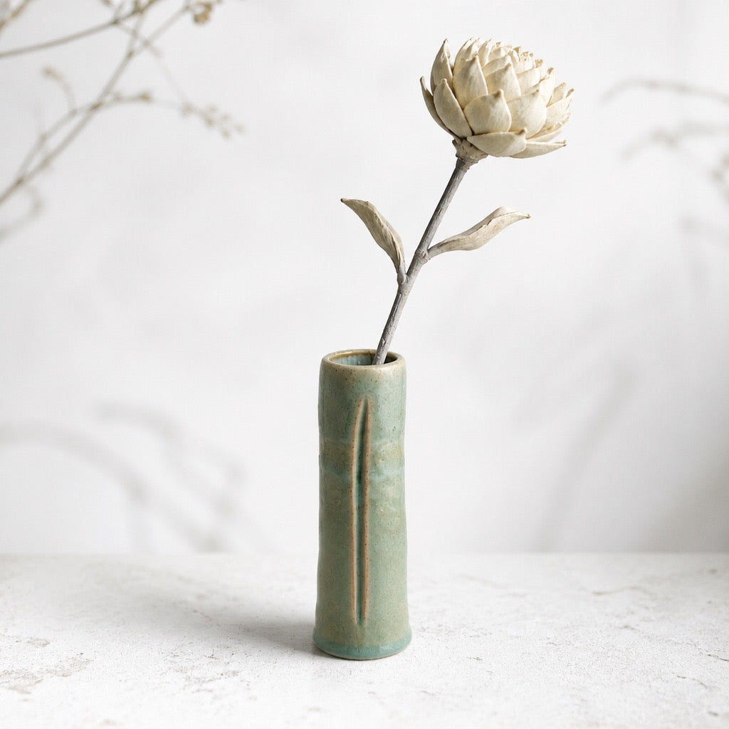 Vase cylindrique KYO en grès céladon craquelé, présenté avec une fleur, création Terres.me.